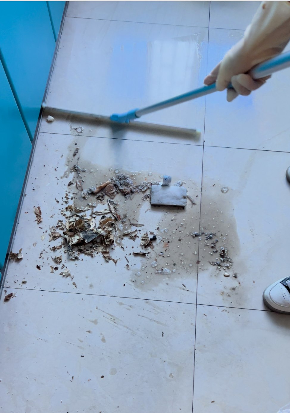 粗开荒现场用刮水器将地面装修污水和碎屑集中推除