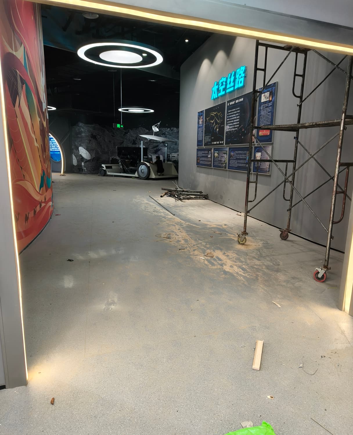 施工前现场原貌:展馆硬装完工实拍,全屋墙面顶面布满装修浮尘,地面散落大量水泥结块与玻璃胶残留